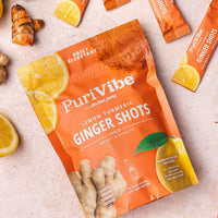 PurviVibe Lemon Turmeric Ginger Shots packaging with ginger and lemon on a light background